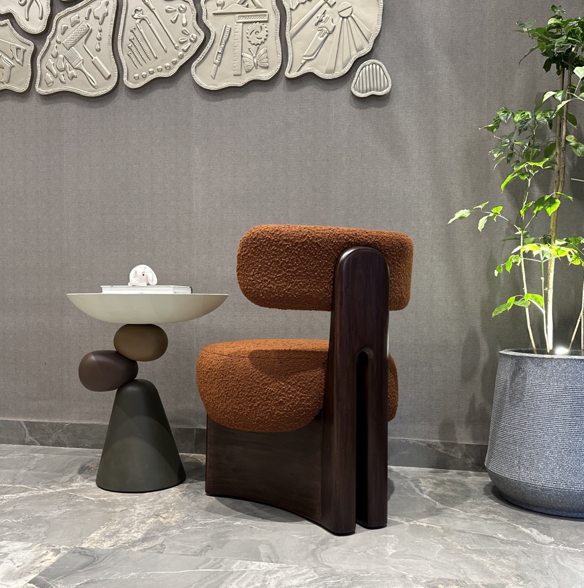 Sculptural brown lounge chair with a compact side table